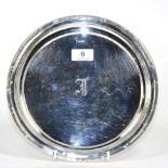 A circular silver tray, Hammond, Creake & Co, Sheffield 1911, with reed and ribbon border, 25.5cm