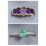 An emerald and diamond ring, an oval cut emerald in a claw setting, to diamond set shoulders,