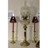 A brass column oil lamp and a pair of candlesticks