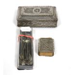 A filigree white metal box and cover; a similar match box holder; and a set of spoons with coin