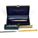 A silver Yard-O-Led pencil, in box and packaging; a Must de Cartier ball point pen; another silver