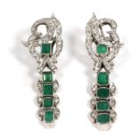 A pair of emerald and diamond pendant earrings, eight-cut diamond set scroll tops suspend a row of