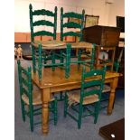 A pine kitchen table together with six green painted rush seated dining chairs (7)