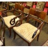 A pair of mahogany armchairs with saber shaped legs