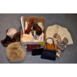 Assorted costume accessories, including a grey fur muff, mink hats, other hats, brown suede