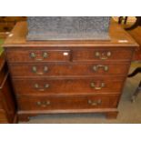 An early 19th century oak and mahogany cross banded chest of drawers comprising three long drawers