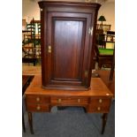 An early 19th century oak corner cupboard and a mahogany side table with central drawer and four