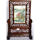 A Chinese porcelain famille rose table screen with a pierced hardwood frame
