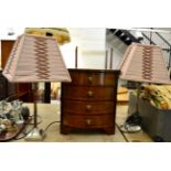 A small mahogany inlaid bow fronted chest of drawers and a pair of table lamps with shades