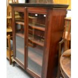 A glazed mahogany bookcase on cabriole supports