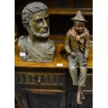 A 20th century bust of a Roman Emperor and a Continental painted figure of a boy seated, impressed