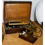 A watchmakers lathe with collets, contained in a wooden case, and a watchmakers hand cutting wheel