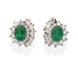 A Pair of 18 Carat White Gold Emerald and Diamond Cluster Clip Earrings, an oval cut emerald in a