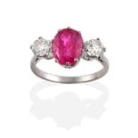 A Burmese Ruby and Diamond Three Stone Ring, an oval cut ruby spaced by two round brilliant cut