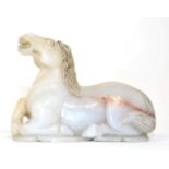 A Chinese Jade Figure of a Horse, in 18th century style, naturalistically modelled recumbent, its