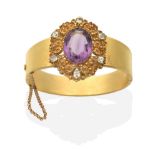 An Amethyst and Chrysoberyl Bangle, an oval cut amethyst within a cannetille frame set with six