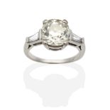 A Solitaire Diamond Ring, an old European cut diamond, in a claw setting, to tapered baguette cut