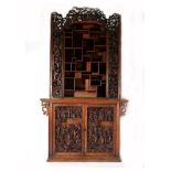 A 19th Century Chinese Softwood Display Cabinet, profusely carved throughout with Oriental figures