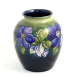 Walter Moorcroft (British, 1917-2002): A Clematis Pattern Vase, on a green/blue ground, impressed