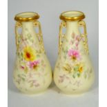 A pair of Royal Worcester China Works floral painted twin handled gilt highlighted vases, 26cm