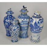 A Chinese porcelain blue and white vase and cover decorated with buildings and three other similar