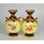 A pair of Royal Crown Derby floral painted twin handled gilt highlighted vases, 22cm