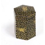 A Japanese lacquered papier mâché hexagonal box and cover, 19th century, gilt with scrolling