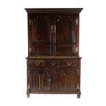 An 18th Century Joined Oak Kitchen Press Cupboard, the upper section with a bold cornice above