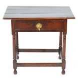 An 18th Century Joined Oak Table, the boarded top above a long frieze drawer, raised on turned