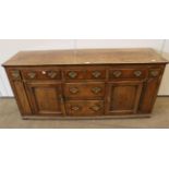 A George III Oak Enclosed Dresser, late 18th century, with an arrangement of five frieze drawers and