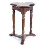 A Victorian Carved Oak Triform Occasional Table, raised on turned and stop-fluted supports joined by