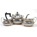 A matched silver three piece tea service, Shefield 1906/07, part fluted with gadroon and shell