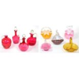 ~ Four cranberry glass jugs and stoppers, together with five assorted glass baskets