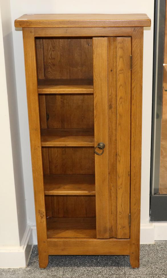 An Oak CD Cabinet, modern, with three fixed shelves flanked by a cupboard door fitted with slides to