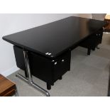 A Castelli Black Dense Resin with Rubber Nosing Rectangular Office Table, raised on polished tubular