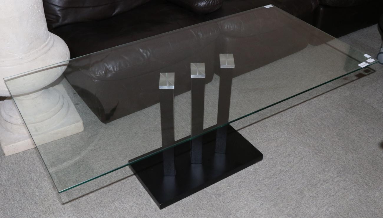 A Glass Top Coffee Table, modern, with rectangular top, raised on a black ash base, 120cm by 60cm by