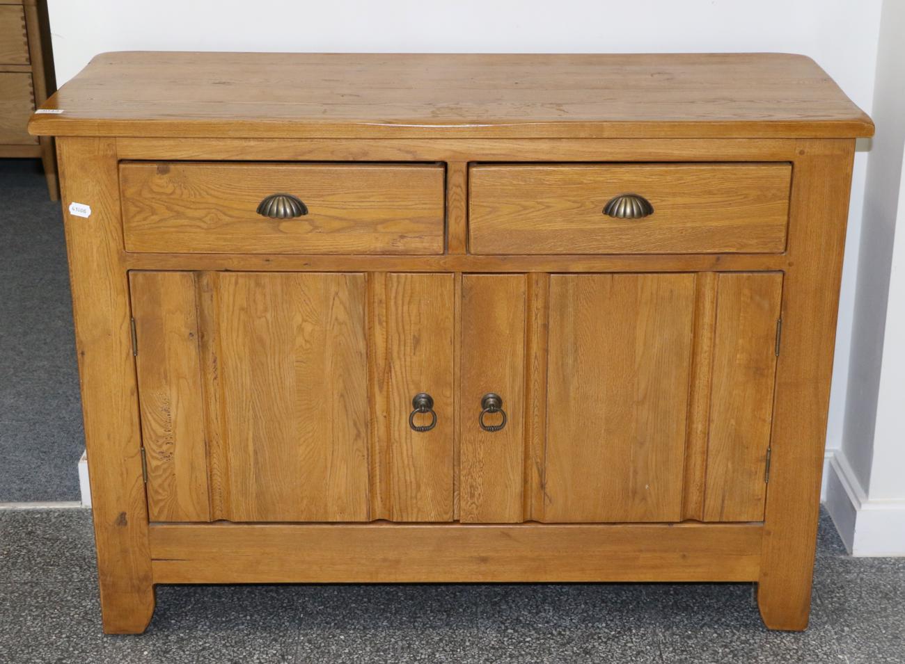 An Oak Sideboard, modern, with two drawers above cupboard doors enclosing a shelf, 123cm by 50cm