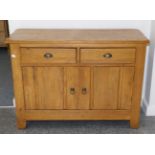 An Oak Sideboard, modern, with two drawers above cupboard doors enclosing a shelf, 123cm by 50cm