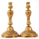 A Pair of Gilt Bronze Candlesticks, in rococo style, with wrythen fluted sockets, leaf sheathed