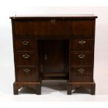 A George II Walnut and Rosewood Crossbanded Kneehole Desk, 2nd quarter 18th century, the hinged