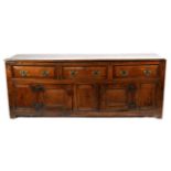 An Early 18th Century Oak Enclosed Low Dresser, the moulded top above three long drawers, the base