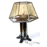 An Art Deco Table Lamp, the hexagonal glass and chrome shade with painted nude dancers, on a