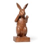 Woodpeckerman: A Stan Dodds (1928-2012) Carved English Oak Boxing Hare, in an upright stance on hind