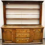 A Late George III Oak Enclosed Dresser, circa 1800, the rack with two shelves between fluted