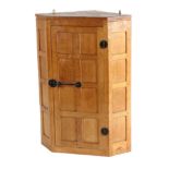 Mouseman: A Robert Thompson English Oak Hanging Corner Cupboard, the single door opening to reveal