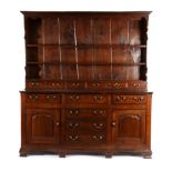 A George III Oak Enclosed Dresser, early 19th century, the rack with arched apron above two fixed