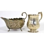 An Indian white metal sauce boat and a silver christening mug (2)