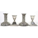 A pair of Victorian silver candlesticks decorated with foliage and flowers; together with a