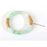 A Jade Bangle, with chased mounts, measures 6.5mm inner diameter . The bangle is in good to fair