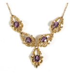 An Amethyst Necklace, the front with oval cut amethysts in claw settings within fancy c-scroll